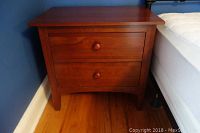 Front view of the wooden night table showing 2 drawers and smooth finish.