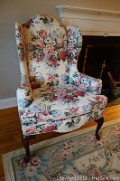 Front view of Ethan Allen Queen Anne style armchair with floral upholstery, showing wingback and wooden legs.