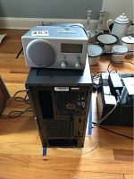 Phentex computer case with Boston Acoustics Receptor radio on top, surrounding household items in background