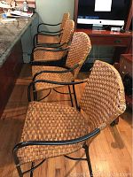 Four wicker bar stools aligned side by side, showing overall frame and seat design.