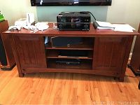 Full front view of console with open shelves and electronics on top