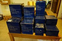 Original blue Towle Full Lead Crystal boxes stacked on a table, showing unopened packaging for the stemware set.
