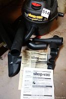 Full view of Shop-Vac vacuum with hose and attachments laid out, along with instruction manual on floor