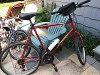 Full side view of red Outpost GT bicycle with visible Shimano gear system and water bottle on frame.