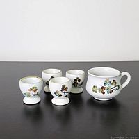 Front view of four egg cups and one cup displaying Shamrock pattern
