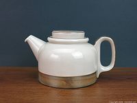 Left side view showing full teapot profile with lid on
