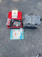 Lot overview showing code reader in red case, cables, manual, battery box, sealed blade package