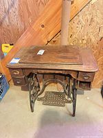 Full view of treadle sewing machine cabinet with drawers and cast iron base