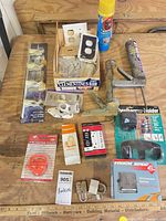 Overview of lot showing caulk gun, CB speaker box, spray foam, padlocks, suction puller, GFCI, and organizer bar