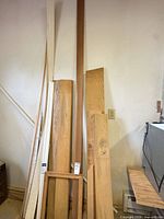 Overall view of assorted lumber pieces leaning against wall