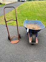 Wheelbarrow and hand truck side by side on driveway