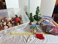 overview of lot showing ornament bin, tabletop trees, floral bags, stocking
