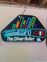 Front view of illuminated Coors Light The Silver Bullet neon sign displaying full graphic