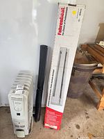 Boxed Fahrenheit electric baseboard heater beside portable oil radiator