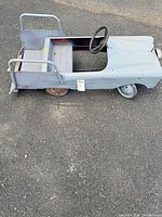 Left side and interior view of gray metal pedal car