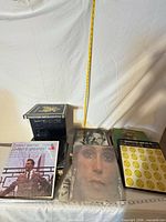 Stack of assorted LPs including Johnny Mathis, Cher sleeve visible; measuring tape for scale