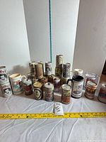 Group overview of cans and mugs with tape for scale