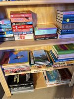 Three shelves of assorted paperbacks and hardcovers showing variety of sizes and subjects