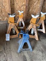 Five jack stands grouped on wood floor