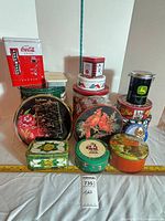 Group shot of all tins with measuring tape for scale