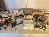 Wide view of assorted VHS tapes, DVDs and audio cassettes on table