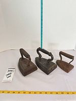All three sad irons with rulers for scale