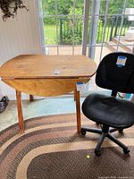 Table with one leaf folded and office chair placed beside it