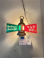 Front view showing illuminated VAT 69 light with red and green panels