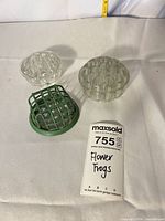 All three flower frogs on table with lot tag