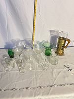 Group view of all thirteen glassware pieces with measuring tape for scale