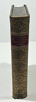 Spine view showing gilt decoration, red title label, and publisher/date detail