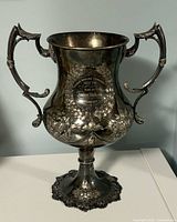 Full view of two-handled antique trophy cup on pedestal base