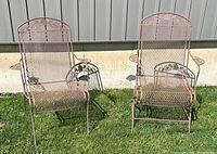 Front view of two matching wrought iron patio chairs on grass