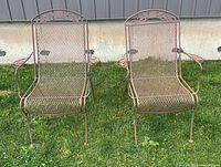 Front view of two wrought iron patio chairs on grass
