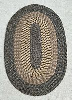 Full view of oval braided jute rug on light surface