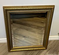 Front view of rectangular gold-framed beveled mirror
