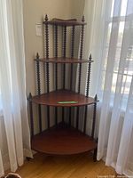 full view of four-tier wooden corner shelf in corner
