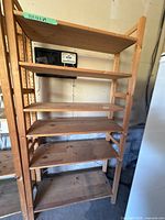 Full view of wooden shelving unit showing five shelves