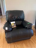 Front view of black faux leather recliner with box on seat