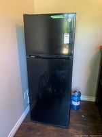 Front view of black two-door refrigerator showing GE logo and overall exterior
