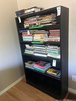 Front view of entire black bookshelf filled with books