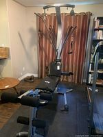 Full view of Bowflex home gym showing bench, leg attachment, cable pulleys and resistance rods