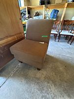 front view of brown slipper chair showing upholstery and wood legs