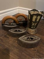 Group view: two irons with handles, additional iron bases, decorative metal vase