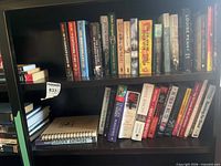 Two shelves of assorted hardcover and paperback fiction and non-fiction titles including The Hunger Games trilogy