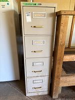 Full front view of four-drawer metal filing cabinet