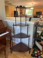 Full view of four-tier corner shelf placed against half wall