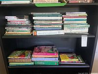 Overview of upper shelf with multiple gardening books including Natural Stonescapes and The Complete Book of Practical Gardening