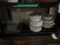 Shelf with nested glass bake pans and stacked white ceramic casseroles
