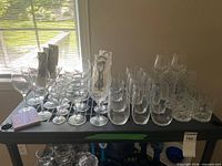 Full lot on shelf showing variety of glassware, sign, charms